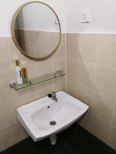 a white sink in a bathroom with a mirror at Garden Homestay in Kulai