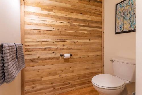 La salle de bains est pourvue d'un mur en bois et de toilettes. dans l'établissement Elevated Living at Bangor Downtown Penthouse, à Bangor