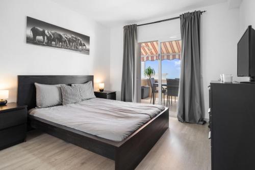 Un dormitorio con una cama grande y un balcón. en Holiday relax apartment, en Adeje
