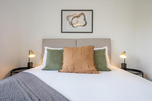 a bedroom with a large white bed with two lamps at Trinity View by Tŷ SA - Beautiful 5 bed in Newport in Caerleon