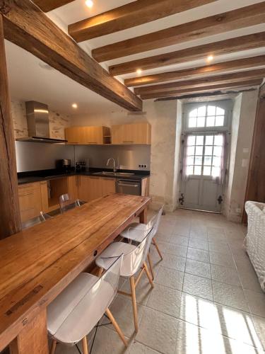 une cuisine avec une grande table et des chaises en bois dans l'établissement Demeure La Lande Fleurie, à Feneu