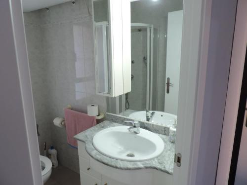a bathroom with a sink and a mirror and a toilet at Tu oasis, a la orilla del mar in Salou