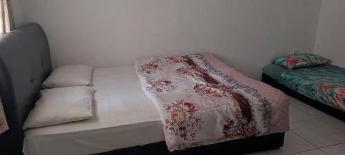 un letto con una coperta in una stanza di MAIDEEN HOMESTAY CAMERON HIGHLANDS a Brinchang