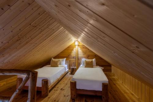 um quarto com 2 camas num sótão de madeira em Elivaas Everly Luxury 1BHK Entire Home in Narkanda em Shimla