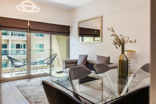 een woonkamer met een glazen tafel en een bank bij Renovated 1 Bed Al Alka 1 In The Greens in Dubai