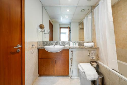 a bathroom with a sink and a toilet and a mirror at Renovated 1 Bed Al Alka 1 In The Greens in Dubai