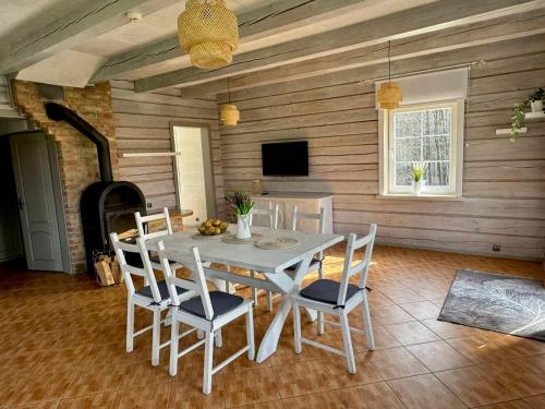 a dining room with a white table and chairs at Two lakes villas&camps in Markutiškės