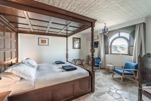 Un dormitorio con una cama grande y una silla. en Hotel Castillo de Monda, en Monda