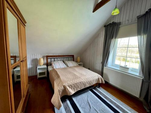 a bedroom with a bed and a large window at Two lakes villas&camps in Markutiškės