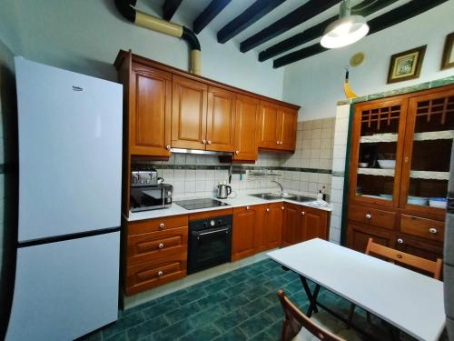 - une cuisine avec des placards en bois et un réfrigérateur blanc dans l'établissement Casa Virginia, à Altea