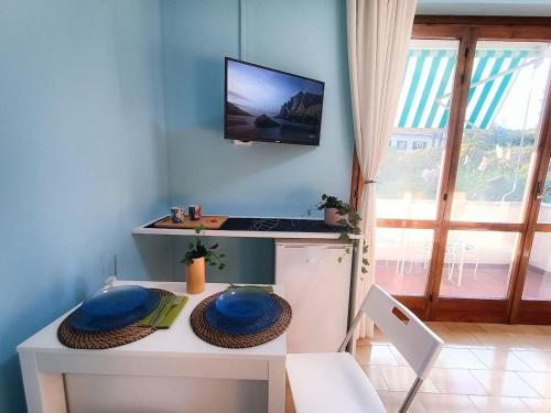 cocina con mesa y TV en la pared en Bellagio Panoramic Mini Loft Giove, en Bellagio