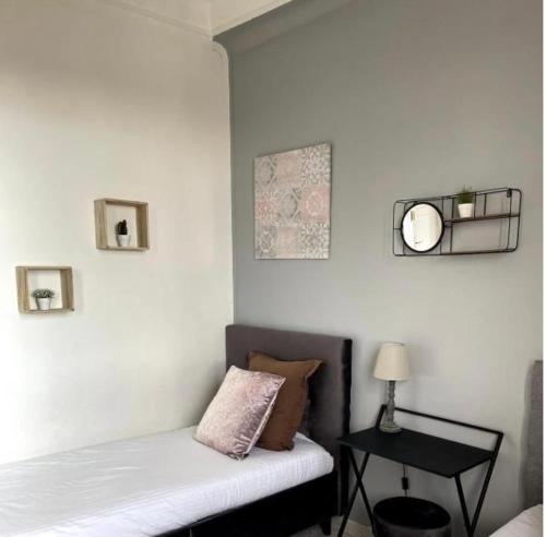 Cette chambre comprend un lit et une table avec un miroir. dans l'établissement Appartements Lumineux, à Marseille