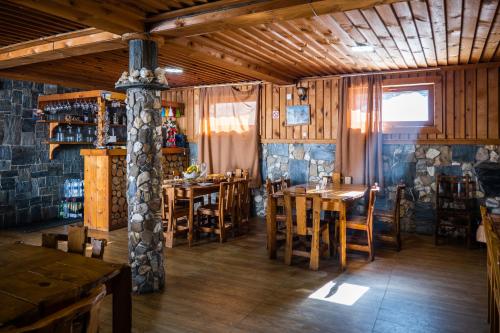 een restaurant met houten tafels en stoelen in een kamer bij Guesthouse Ushguli Maspindzeli in Ushguli