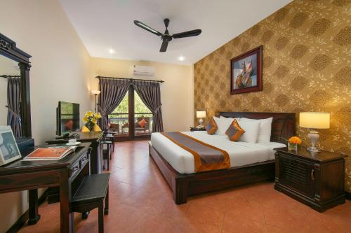Pokój hotelowy z łóżkiem i biurkiem oraz łóżkiem o wymiarach 6 x 6 w obiekcie Sea Lion Beach Resort Mui Ne w mieście Mui Ne
