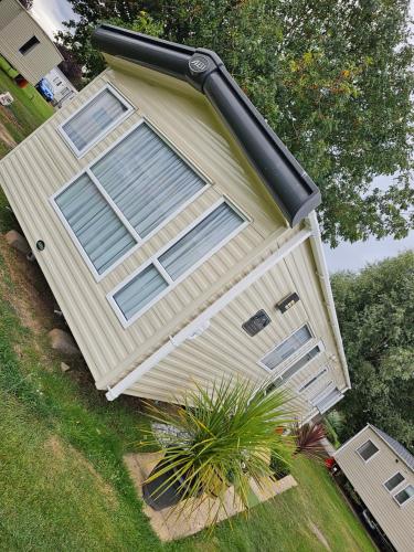 uma casa com um grande poste preto ao lado em 3 Bed Holiday Home, Doniford Bay em Watchet
