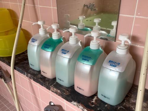 a group of bottles of detergents on a shelf in a bathroom at Makino Kogen 123 Building / Vacation STAY 79154 in Kaizu