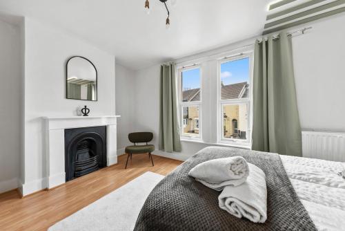 um quarto branco com uma cama e uma lareira em Stylish Appt in Medway ideal for NHS and contractors, free parking em Gillingham