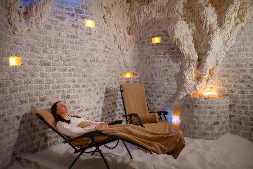 a woman sitting in a rocking chair in a cave at Danubius Hotel Bük in Bük