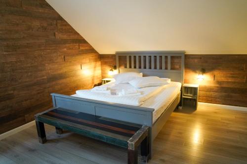 a bedroom with a large bed with wooden walls at Kata - Lak in Băile Tuşnad