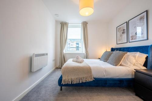 Un dormitorio con una cama azul y una ventana en Waterside by Tŷ SA -Free Parking, en Cardiff