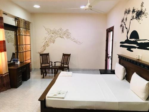 a bedroom with a large bed and two chairs at ROYAL GRAND PARADISE RESORT AND TOURS NEAR COLOMBO in Kelaniya