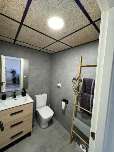 a bathroom with a white toilet and a sink at Ático in Málaga