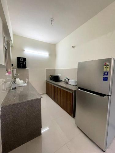 a kitchen with a stainless steel refrigerator and counters at 2BHK 10 min drive to GOI airport & beach at Dabolim in Vasco Da Gama