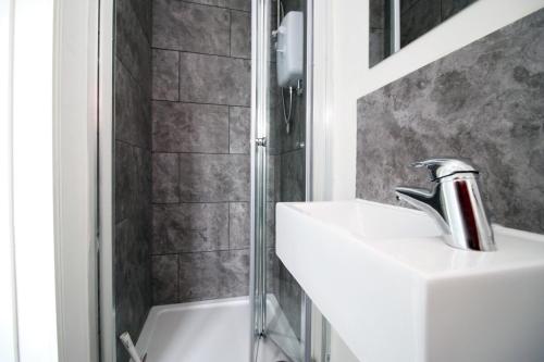 a bathroom with a sink and a shower at Willow Way by Tŷ SA in Nantgarw