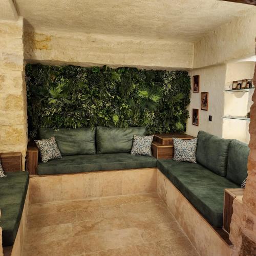a living wall with a green couch in a room at Fresco Cave Suites Cappadocia in Urgup