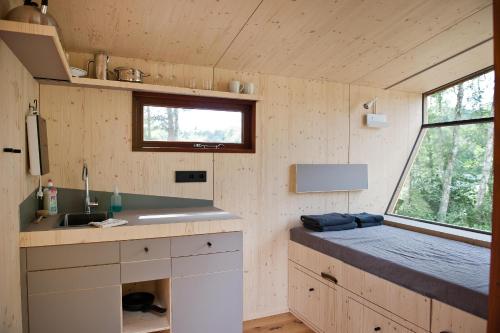 una cocina en una casa pequeña con fregadero y ventana en Sleep Space 3 - Salemer See, en Salem