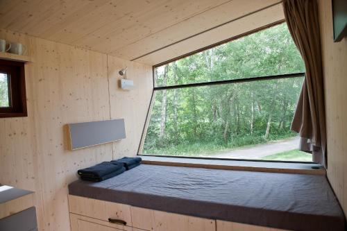 a small bedroom with a window in a tiny house at Sleep Space 3 - Salemer See in Salem