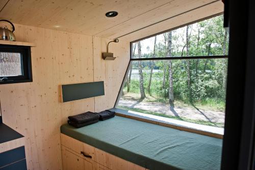 a small room with a window in a forest at Sleep Space 4 - Salemer See in Salem