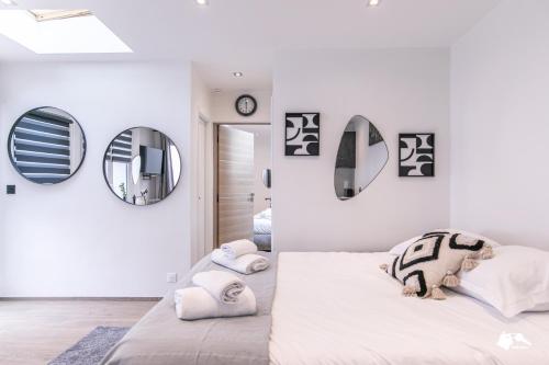 - une chambre avec des murs blancs et un lit avec des oreillers dans l'établissement MBA Levallois Splendide Appart - Proche Paris, à Levallois-Perret