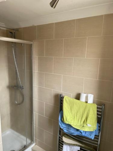 ein Bad mit einer Dusche und einem Handtuch auf einem Kleiderständer in der Unterkunft North East Escape in Holystone