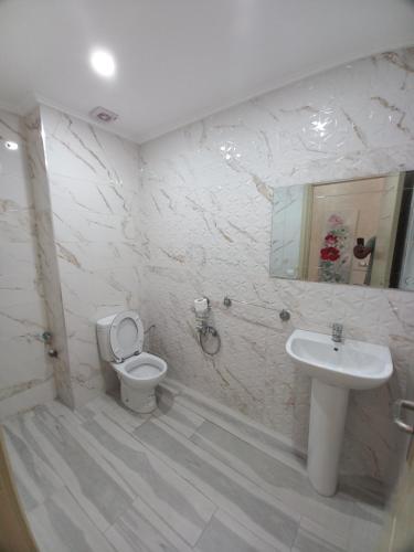 a white bathroom with a toilet and a sink at Dari A10 in Agadir