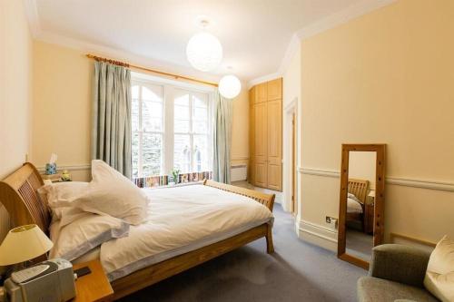 - une chambre avec un lit et une grande fenêtre dans l'établissement Bay View Apartment by Tŷ SA, à Newton