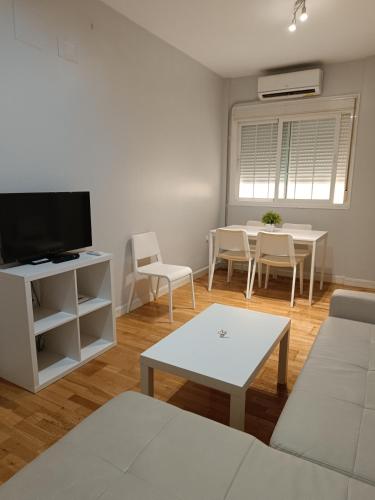a living room with a table and a tv at Apartamentos Aloha 2 Centro El Puerto de Santa Maria in El Puerto de Santa María