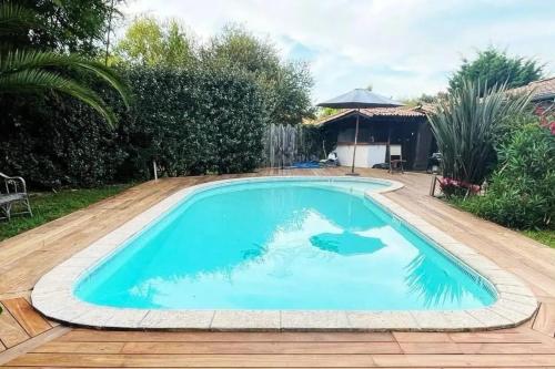 une piscine avec de l'eau bleue dans une cour dans l'établissement Villa élégante à La Teste-de-Buch avec piscine privée, à La Teste-de-Buch