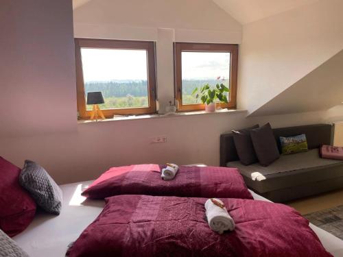 a bedroom with two beds and a couch and two windows at Bergchalet Mirabell - Hofgut in Friedrichshafen