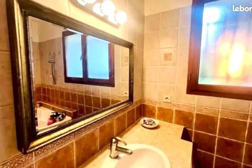 un bagno con un lavandino e un grande specchio di Villa élégante à La Teste-de-Buch avec piscine privée a La Teste-de-Buch