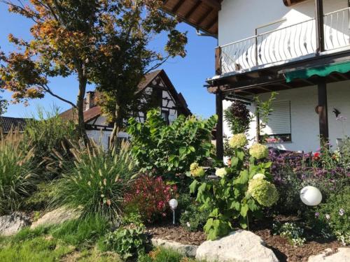 un jardin avec des fleurs en face d'une maison dans l'établissement Bergchalet Mirabell - Hofgut, à Friedrichshafen
