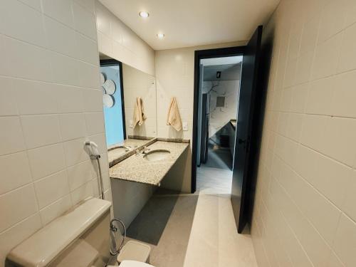 ein Badezimmer mit einem Waschbecken, einem WC und einem Spiegel in der Unterkunft Flat Luxury Chelsea frente ao Dona Lindu in Recife
