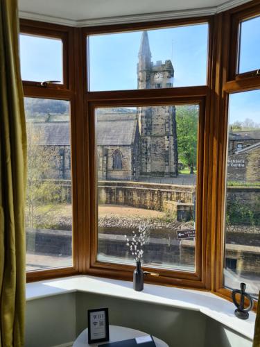 een raam met uitzicht op een kerk bij Stunning River View in Mytholmroyd