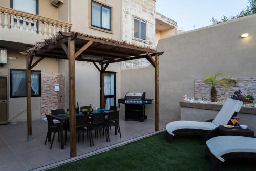 un patio con pérgola de madera, mesa y sillas en Villa Sunview, en Rabat
