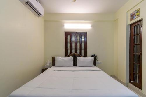 a bedroom with a large white bed and a window at Hotel Mahal in kolkata