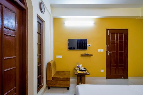 a room with a door and a chair and a table at Hotel Mahal in kolkata