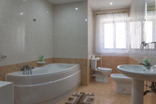 La salle de bains est pourvue d'une baignoire, de toilettes et d'un lavabo. dans l'établissement Villa Sunview, à Rabat