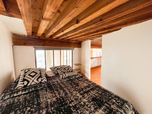 - une chambre avec un lit et un plafond en bois dans l'établissement Suite Cartier, à Lyon