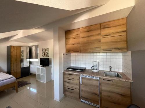 a kitchen with wooden cabinets and a sink at Bergchalet Mirabell - Hofgut in Friedrichshafen