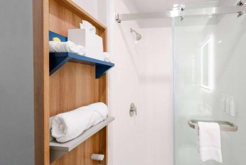 a bathroom with a toilet and a shower with towels at Microtel Inn & Suites Springville in Springville